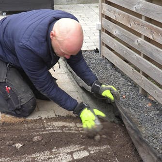 Fliserne skrider: Dæk løbende betonen med jord Fliserne skrider: Dæk løbende betonen med jord